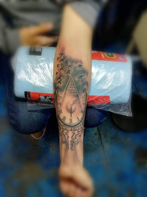 Reloj y pirámide tatuaje realizado por Juliio Tatuajes