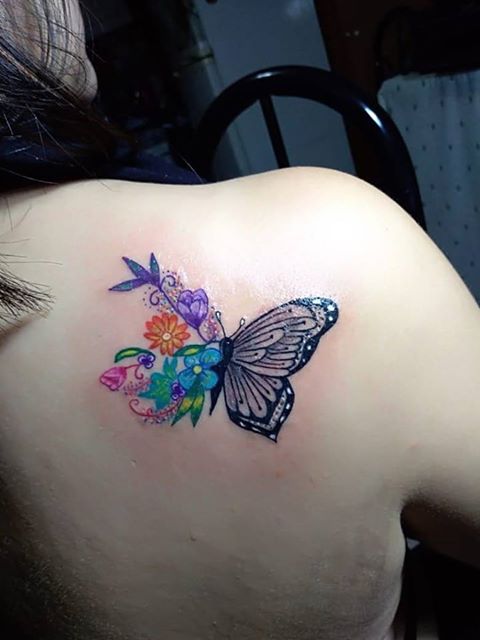 Mariposa y flores tatuaje realizado por Ginebra Lilith