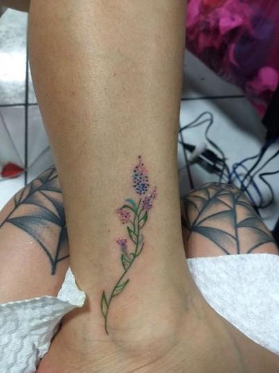 Flor pequeña en el pie tatuaje realizado por Ginebra Lilith