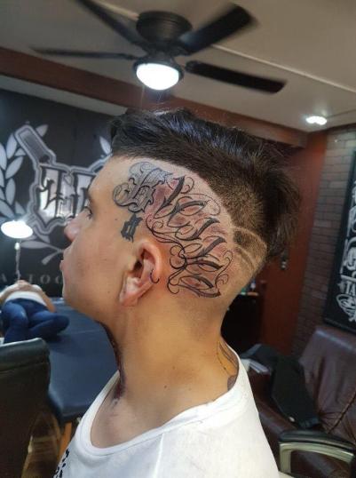 Letras en la cabeza tatuaje realizado por Baloo Rodríguez