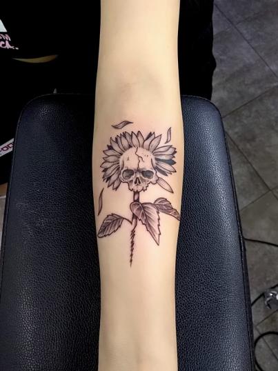 Flor con cráneo tatuaje realizado por Adan dados uno