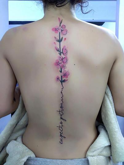 Flores con Nombre en la espalda tatuaje realizado por Adan dados uno