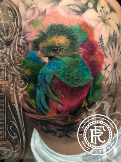 Ave multicolor tatuaje realizado por Fabian Rojas