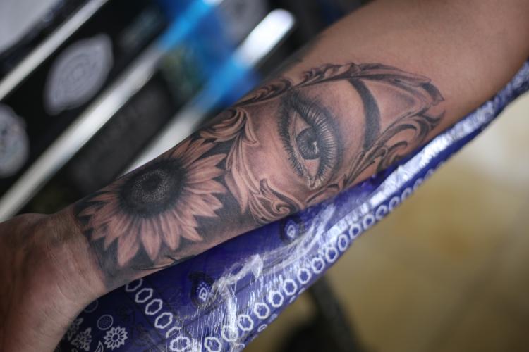 ojo y girasol  tatuaje realizado por Old Gangsters Tattoo Shop