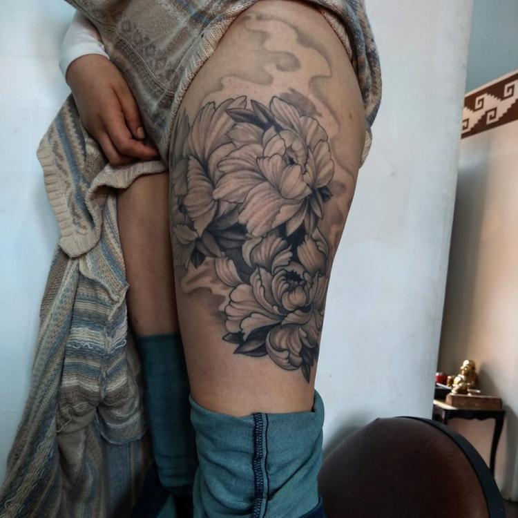 Poenias en la pierna tatuaje realizado por Carlos Koyote Ramirez