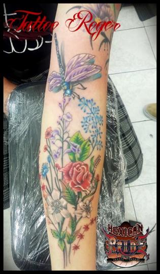 Libelula con flores tatuaje realizado por Roberto Girón