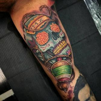 Cráneo y trompo tatuaje realizado por Viernes13 Tattoo Collective