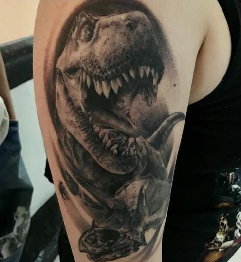 Dinosaurio rex y cráneo  tatuaje realizado por Viernes13 Tattoo Collective
