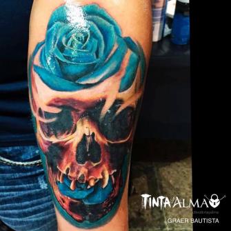 Cráneo y rosa azul tatuaje realizado por Tinta y Alma