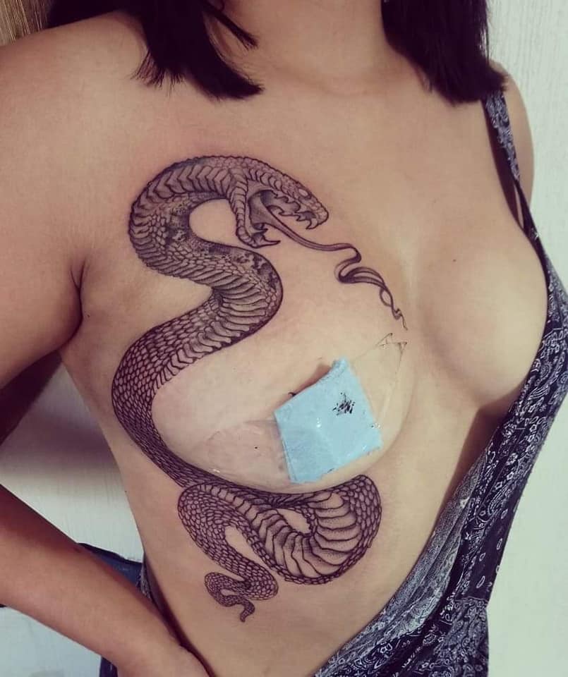 Serpiente en las costillas y pecho tatuaje realizado por Ruth Winchester