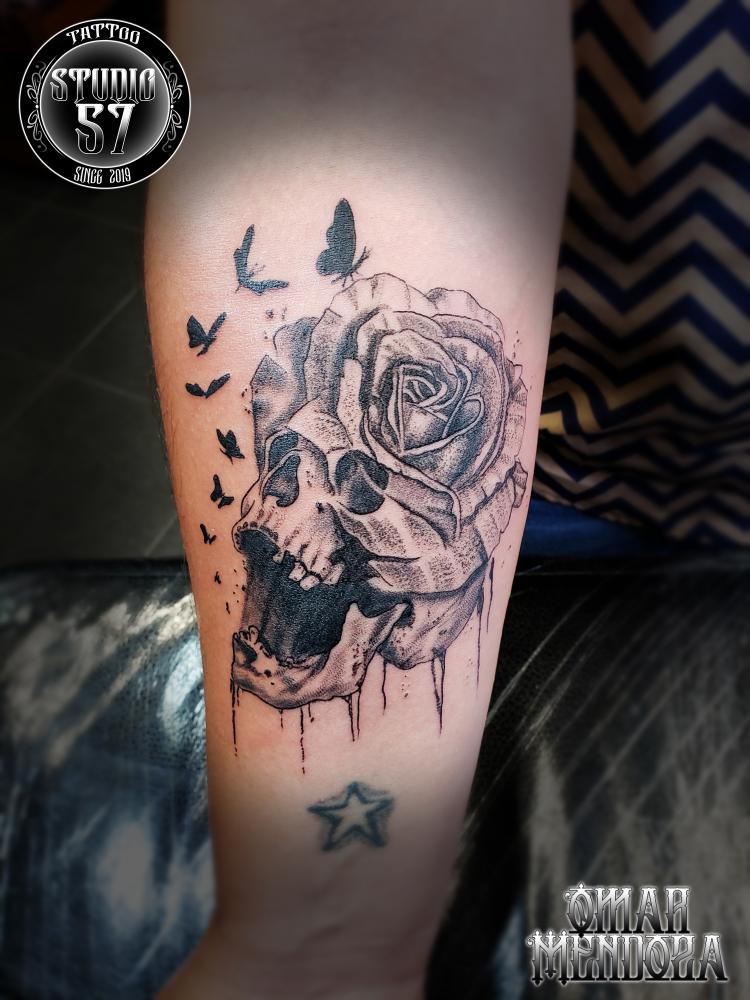 Cráneo y rosa  tatuaje realizado por Omar Mendoza 