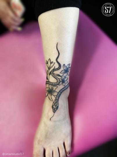 serpiente y cataleyas  tatuaje realizado por Omar Mendoza 