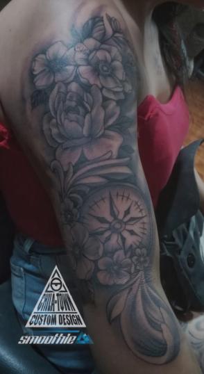 Brújula con flores tatuaje realizado por Chilatown Custom Desing