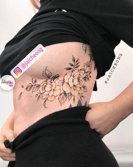 Flores en las costillas tatuaje realizado por Jai Cheong
