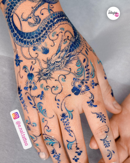 Mano de porcelana con dragón y flor en azul tatuaje realizado por E.nal